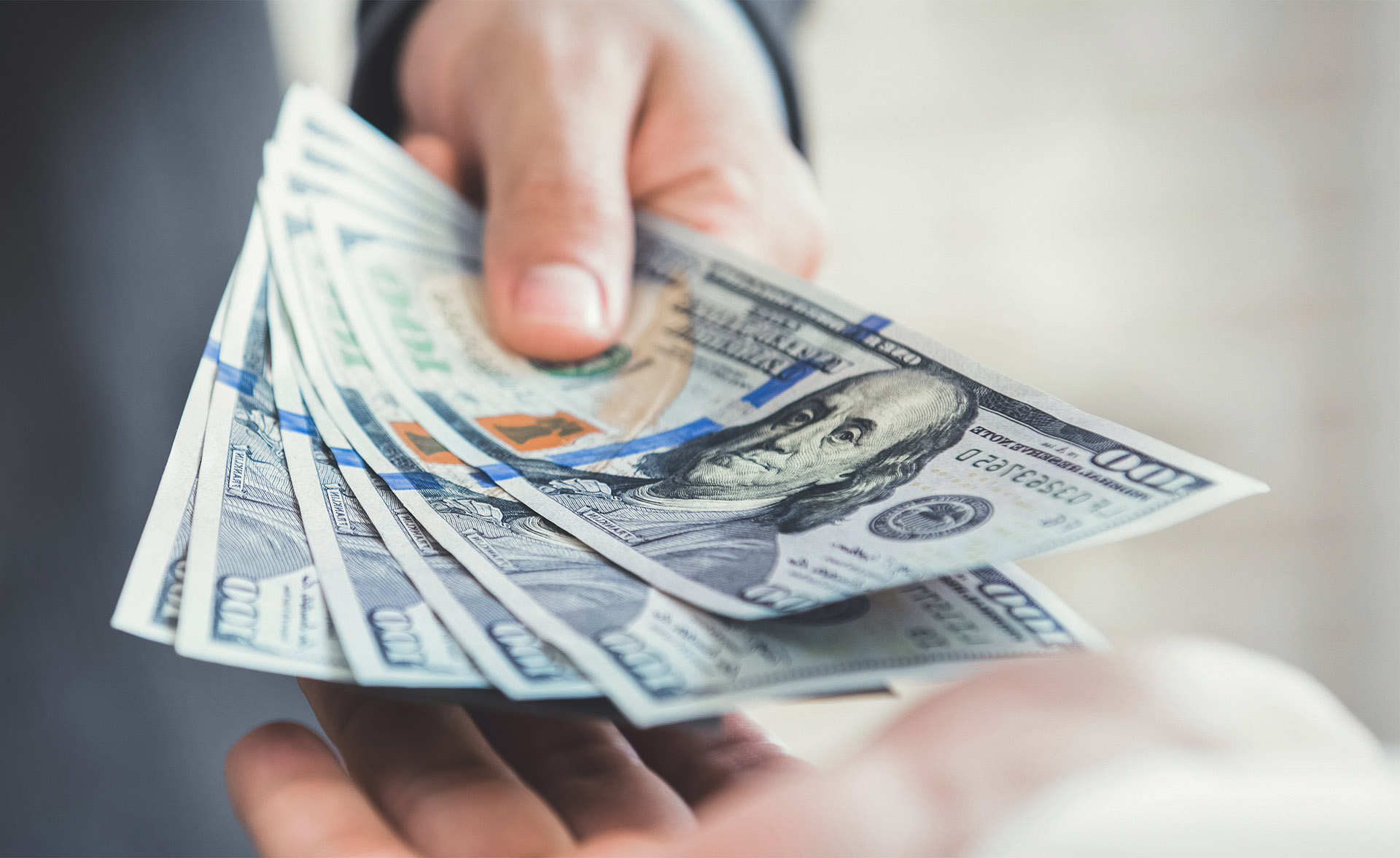 Businessman giving or paying money, US dollar bills