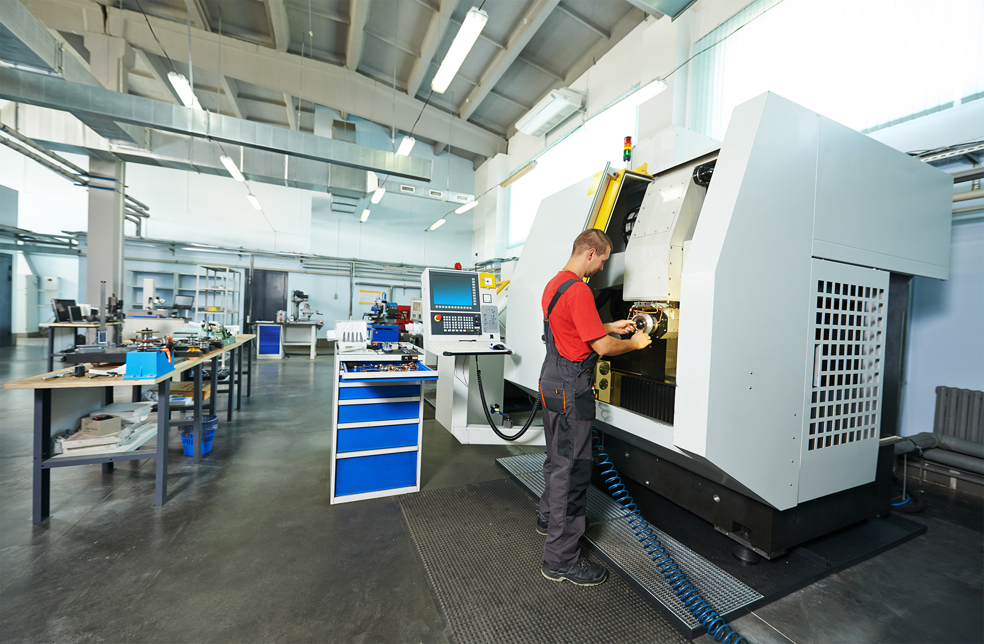 A manufacturing technician working at a CNC lathe