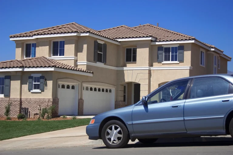 An old car in front of a suburban house