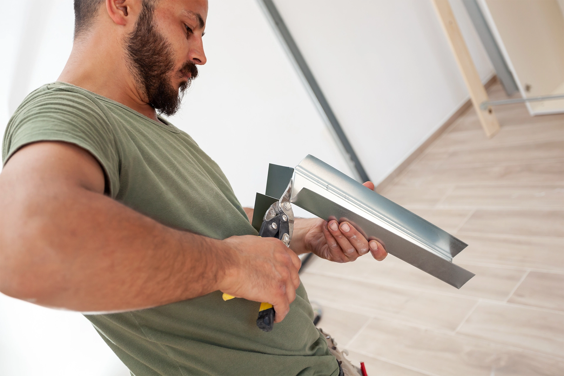 A homeowner cutting metal for a home renovation.