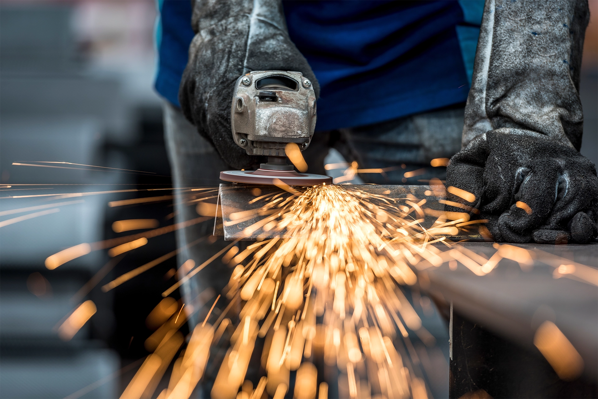 metal-fabricator-grinding A metal fabricator grinding a metal beam