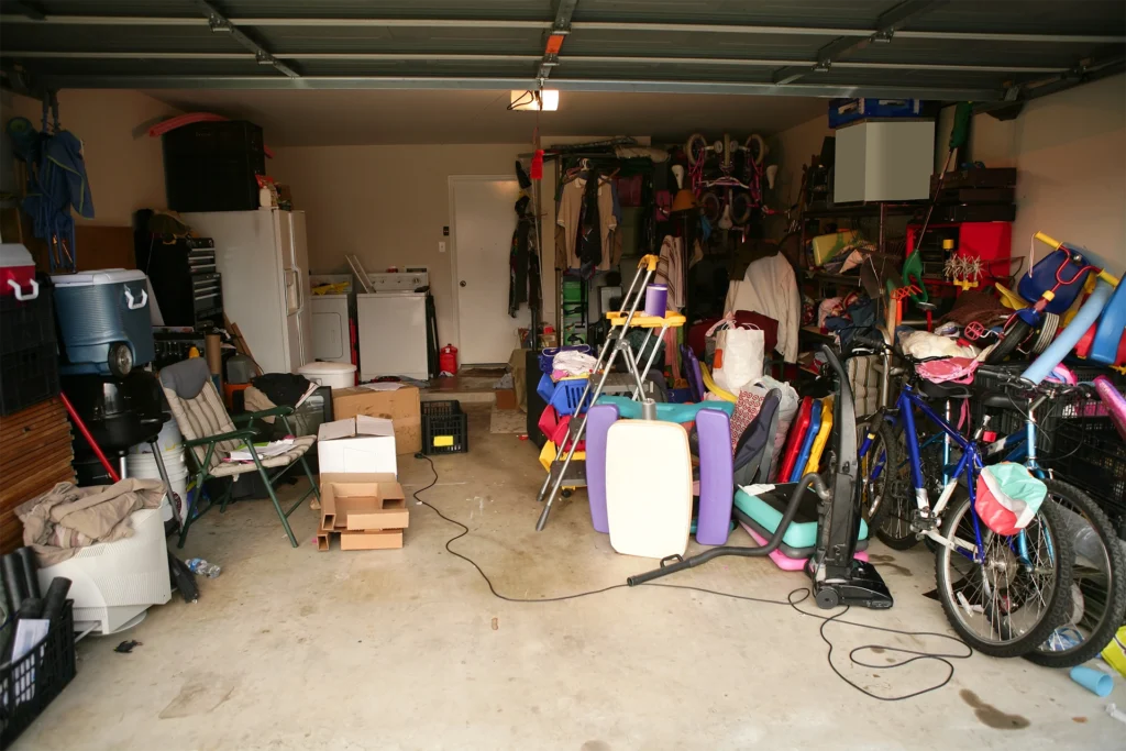 A cluttered garage with many household items, bikes, toys, and equipment.