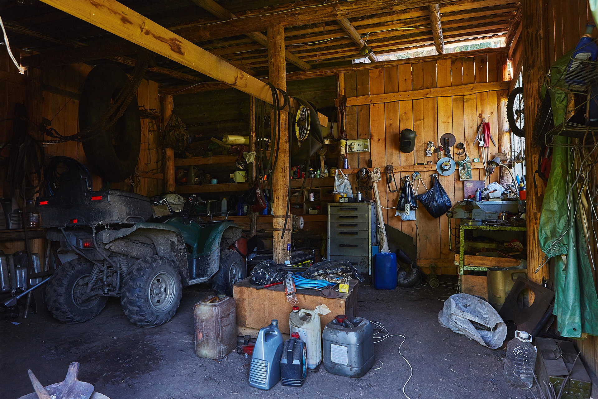 A cluttered shed filled with tools, supplies, and leftover materials.